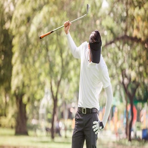 golfer in white shit looks down in disgust