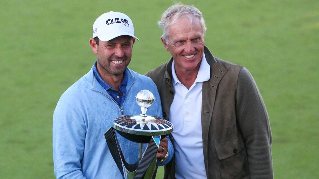 Charl Schwartzel of South Africa holds the winners trophy and poses for a photo with Greg Norman, LIV Golf CEO, after day three of the LIV Golf Invitational at The Centurion Club on June 11, 2022 in St Albans, England.