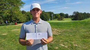 Kevin Lydon holds up his scorecard after shooting 61 in his first collegiate round.