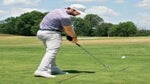 man hits golf ball