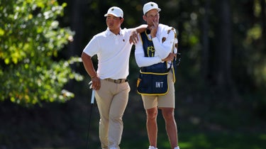 Tom Kim of South Korea and the International Team waits with caddie Joe Skovron on the ninth green during Saturday afternoon four-ball matches on day three of the 2022 Presidents Cup at Quail Hollow Country Club on September 24, 2022 in Charlotte, North Carolina.
