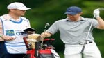 rory mcilroy with his bag and caddie