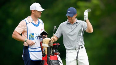rory mcilroy with his bag and caddy