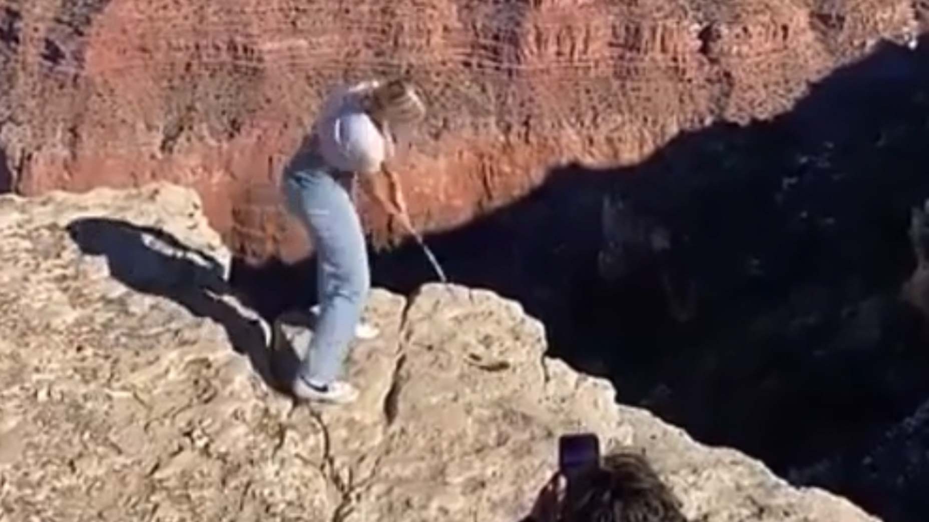 A screenshot of a TikTok influencer hitting a golf ball over the Grand Canyon.