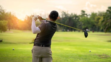 a golfer takes a swing.