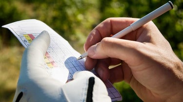 a golfer marks a scorecard