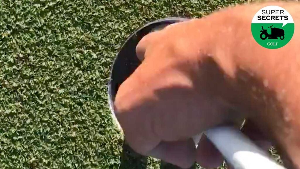 hand getting ball from hole