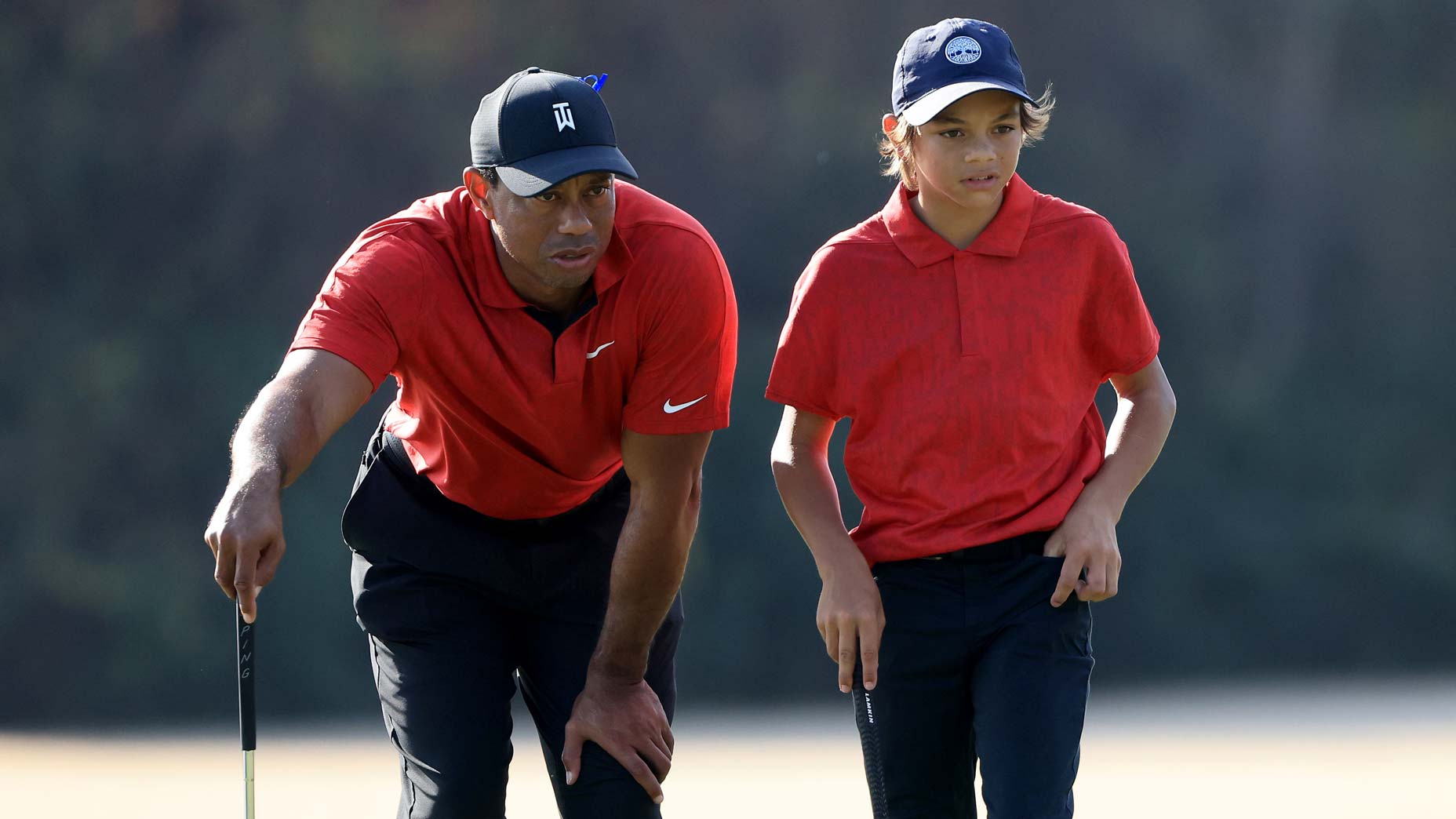 Tiger Woods and Charlie Woods read a putt during the 2021 PNC Championship