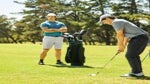 golfer watches other golfer hit