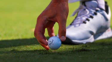 golfer puts ball on tee