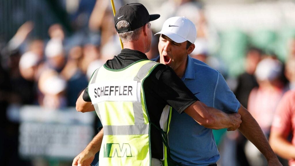 Scottie Scheffler of the United States and caddie Ted Scott celebrate winning on the 18th green during the final round of the WM Phoenix Open at TPC Scottsdale on February 12, 2023 in Scottsdale, Arizona.