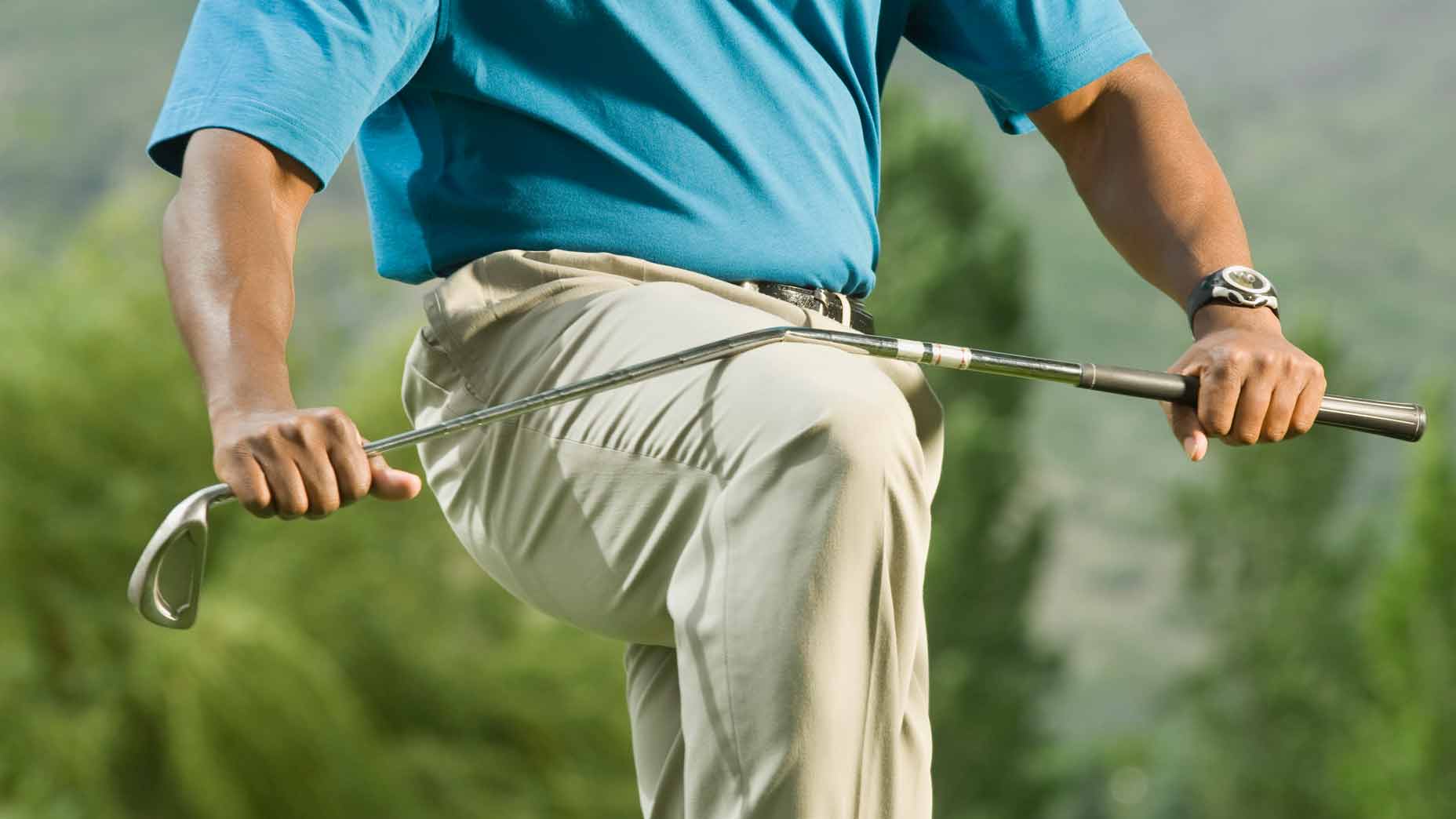 golfer breaks club over his knee
