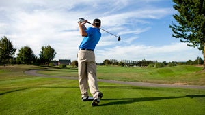 golfer hits ball on golf course