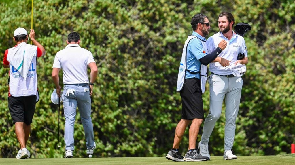Cameron Young and his caddie Paul Tesori smile and hug after defeating Rory McIlroy of Northern Ireland in a playoff on the 12th hole green during the fifth and final day of the World Golf Championships-Dell Technologies Match Play at Austin Country Club on March 26, 2023 in Austin, Texas.