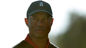 Tiger Woods of the United States prepares to present the trophy to Jon Rahm of Spain after putting in to win The Genesis Invitational at Riviera Country Club on February 19, 2023 in Pacific Palisades, California.