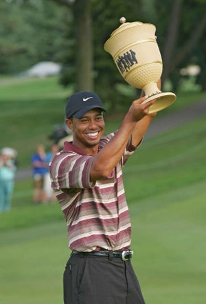 Tiger Woods of the United States celebrates with the trophy after winning the NEC Invitational at Firestone Country Club in Akron, Ohio on August 21, 2005.