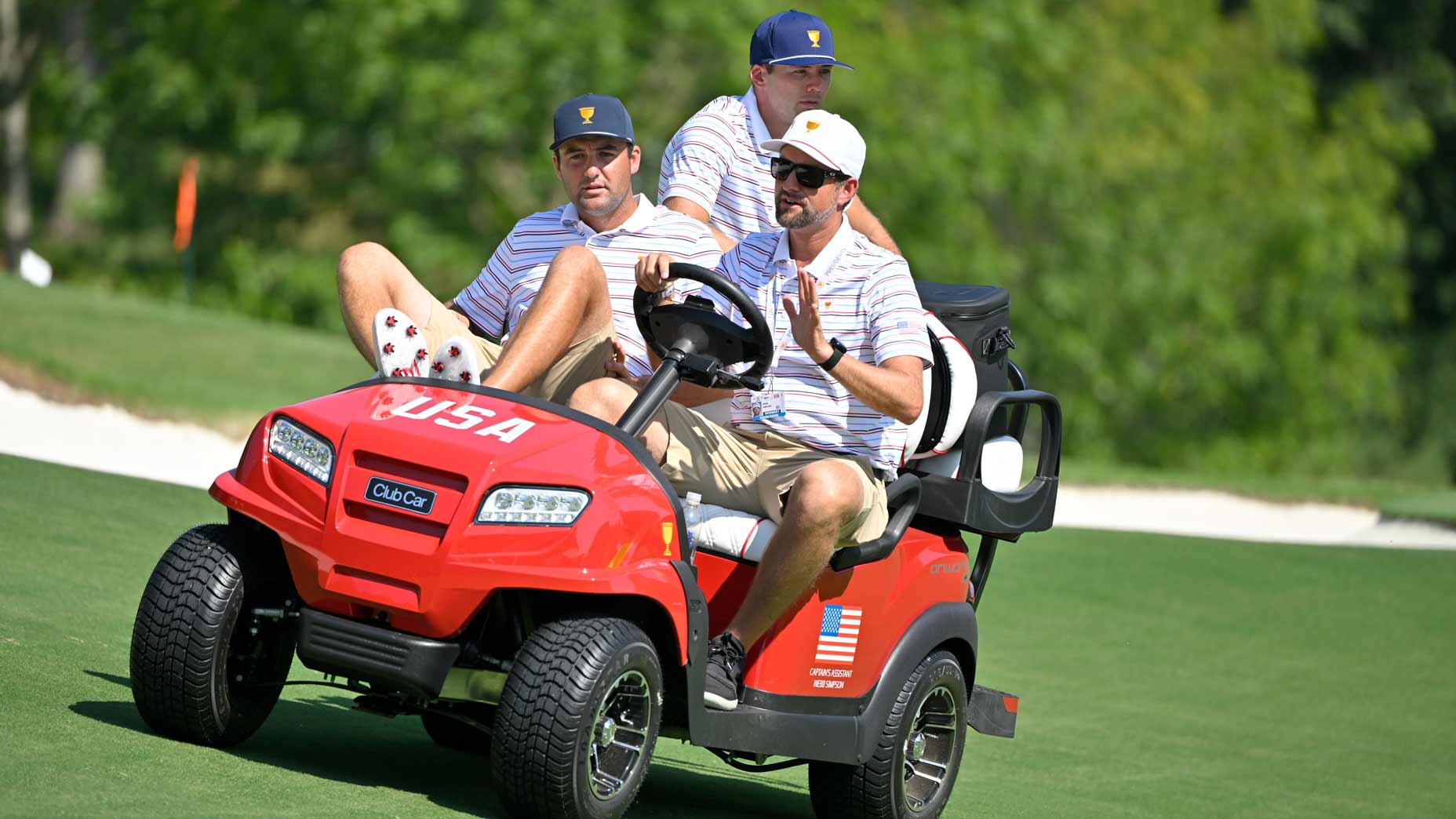 Webb Simpson drives Scottie Scheffler and Sam Burns down the 12th hole prior to Presidents Cup at Quail Hollow September 19, 2022, in Charlotte, North Carolina.