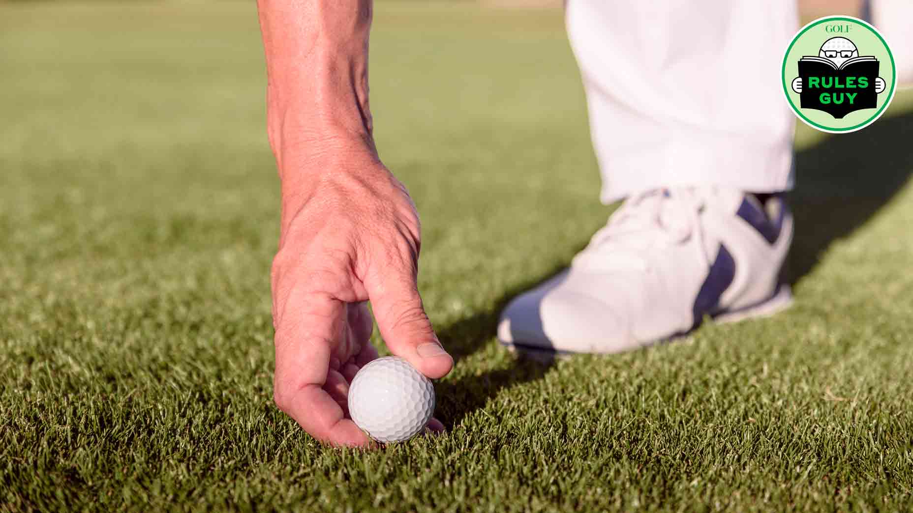 hand placing golf ball