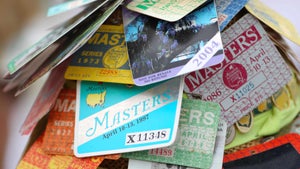 a patron wears a hat with masters badges at augusta national