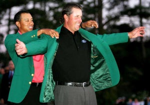 Tiger Woods puts the green jacket on Phil Mickelson after he won the 2006 Masters.