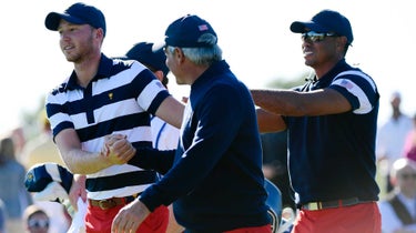 Tiger Woods, Captains Assistant of the U.S. Team and Fred Couples, Captains Assistant of the U.S. Team, congratulate Daniel Berger of the U.S. Team after putting in to win his match and clinch the Presidents Cup during the Sunday singles matches at the Presidents Cup at Liberty National Golf Club on October 1, 2017, in Jersey City, New Jersey.