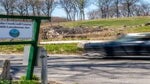 A car drives by the entrance and sign to Cobbs Creek Golf Course in West Philadelphia.