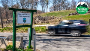 A car drives by the entrance and sign to Cobbs Creek Golf Course in West Philadelphia.