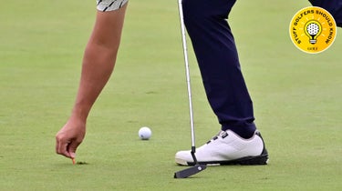 a man fixes a ball mark on the green