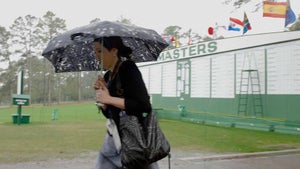 Woman walks in rain at Masters