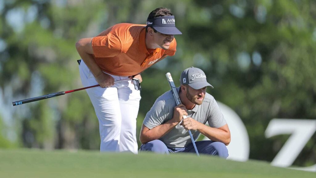 Beau Hossler and Wyndham Clark read a putt at the Zurich Classic.