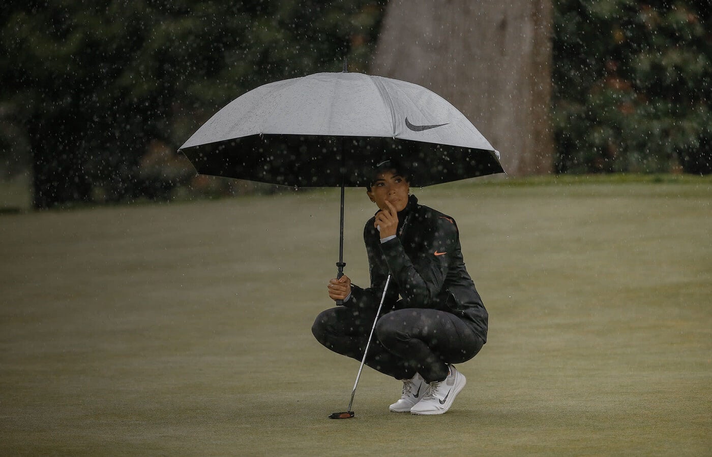 Golfer with an umbrella in the rain