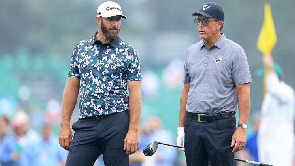 dustin johnson stands with phil mickelson