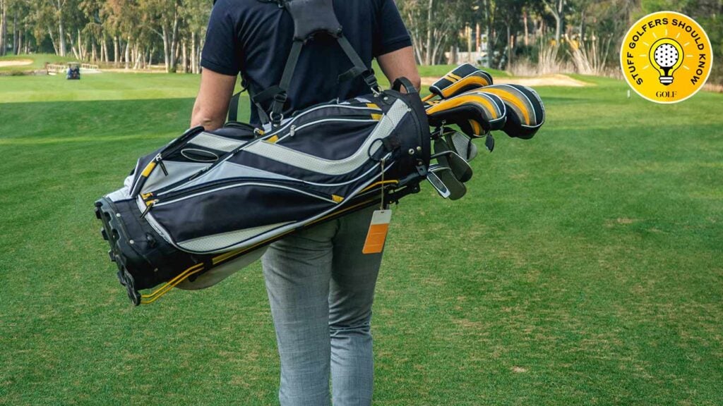 a man carries a golf bag