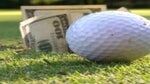 a golf ball and money on the golf course