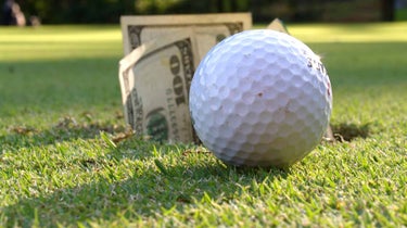 a golf ball and money on the golf course