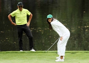 Rickie Fowler of the United States watches his girlfriend Allison Stokke during the Par 3 Contest prior to the start of the 2018 Masters Tournament at Augusta National Golf Club on April 4, 2018 in Augusta, Georgia.
