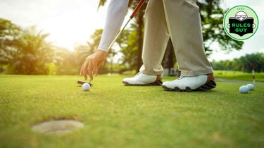 player touching ball on green