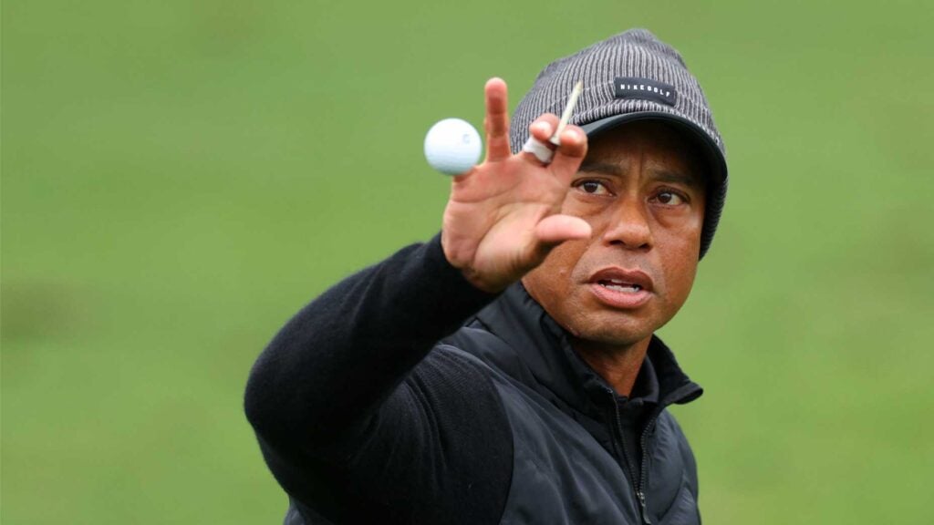 tiger woods grabs golf ball