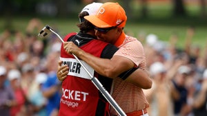 Rickie Fowler of the United States celebrates with his caddie, Ricky Romano, on the 18th green after winning on the first playoff hole during the final round of the Rocket Mortgage Classic at Detroit Golf Club on July 02, 2023 in Detroit, Michigan.