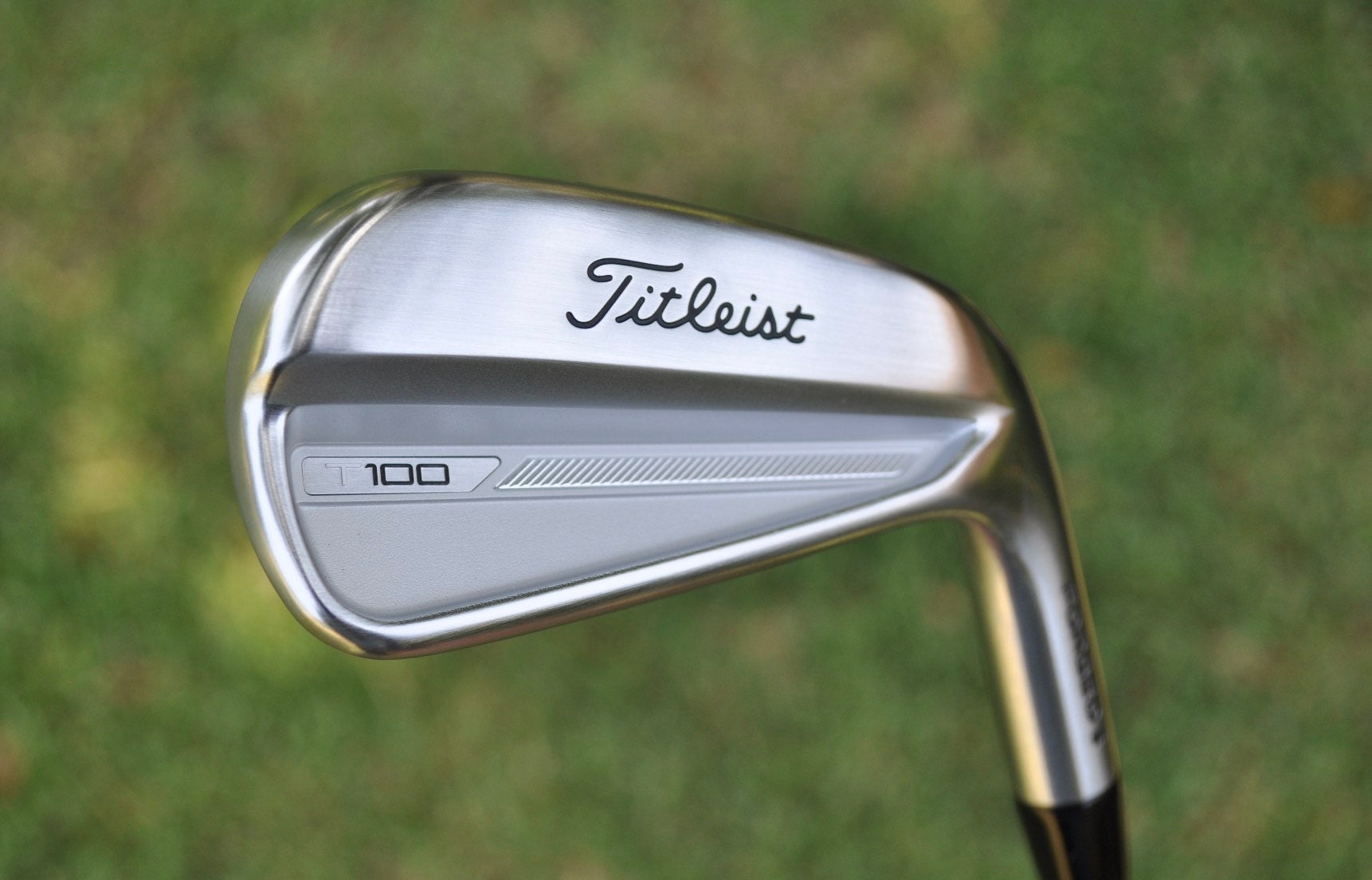 A Titleist T100 iron back bar pictured on a golf course