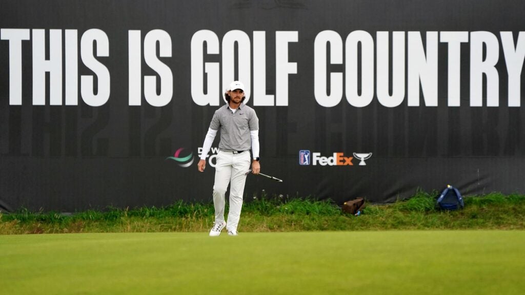 tommy fleetwood walks golf country sign