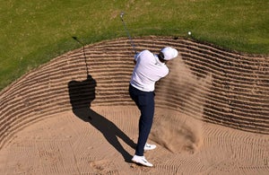 scottie scheffler hits out of a pot bunker on monday