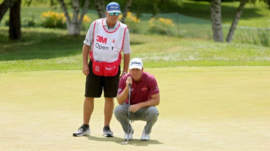 Tom Hoge and caddie read putt at 3M Open