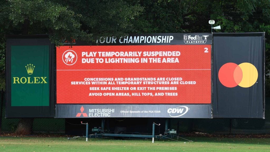 A leaderboard displays a message indicating a suspension of play due to inclement weather during the third round of the TOUR Championship at East Lake Golf Club on August 26, 2023 in Atlanta, Georgia.