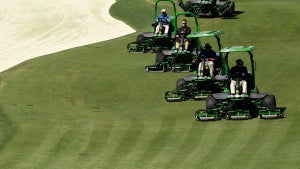 grounds crew cutting grass