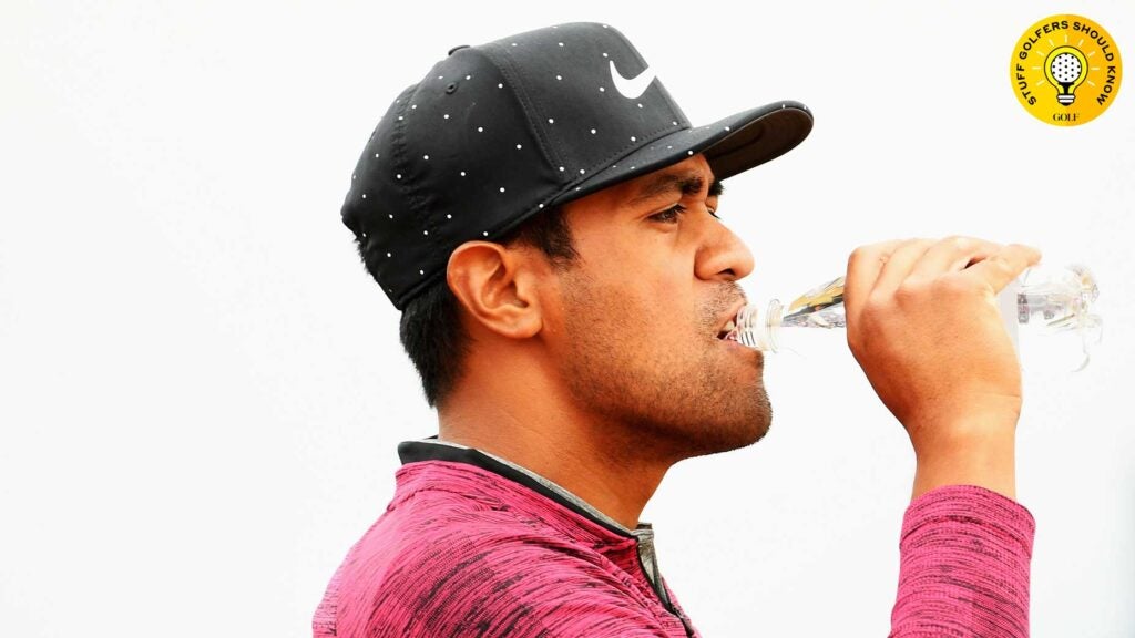 tony finau drinks water on the golf course