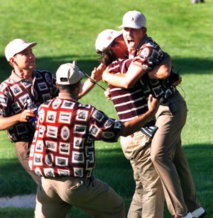 Members of the US team surround Justin Leonard after he sinks a long putt on the 17th green in his match against Jose Maria Olazabal at the 33rd Ryder Cup Matches in Brookline, MA on Sept. 26, 1999.