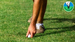 golfer moving ball in rough