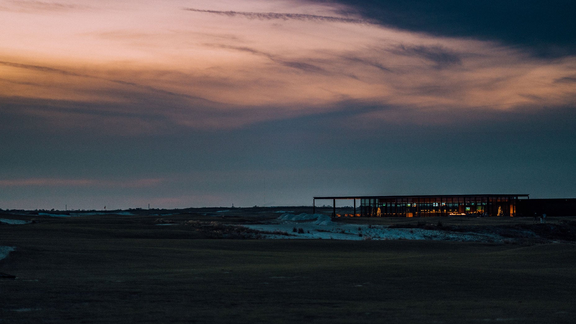 The modern clubhouse at dusk at Streamsong