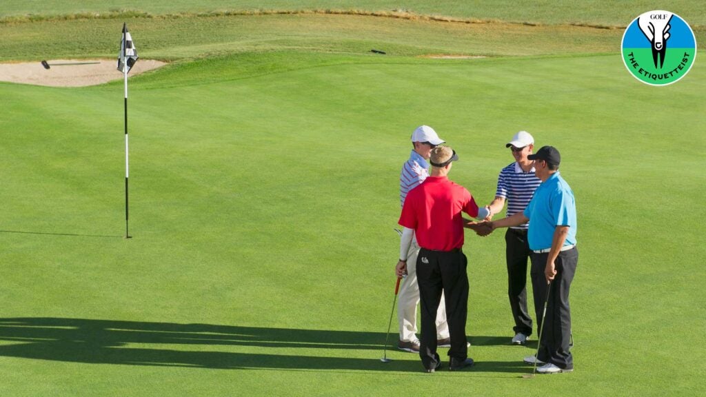 High angle view of men shaking hands on golf course